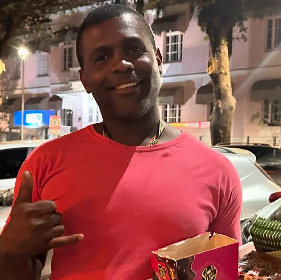 Hebert, vendedor ambulante, sorrindo enquanto oferece seus produtos